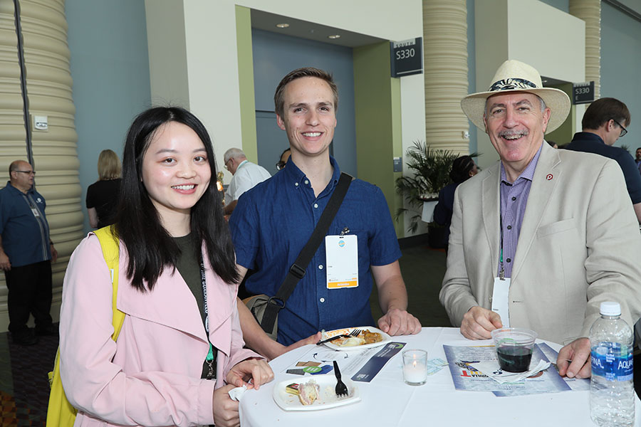 Three people standing at a table at the international reception